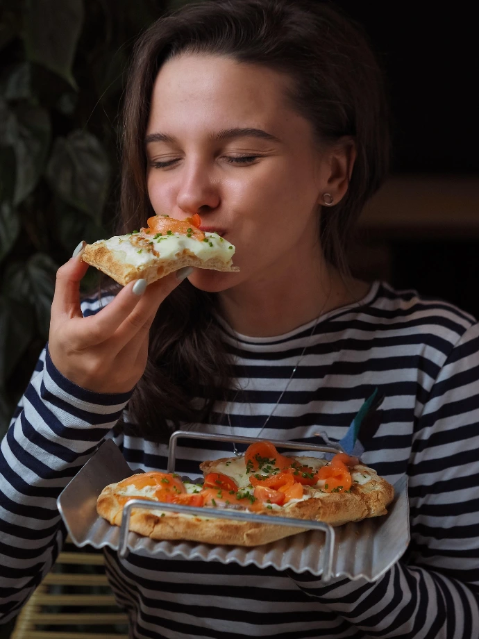 Femme mordant dans une part de pizza